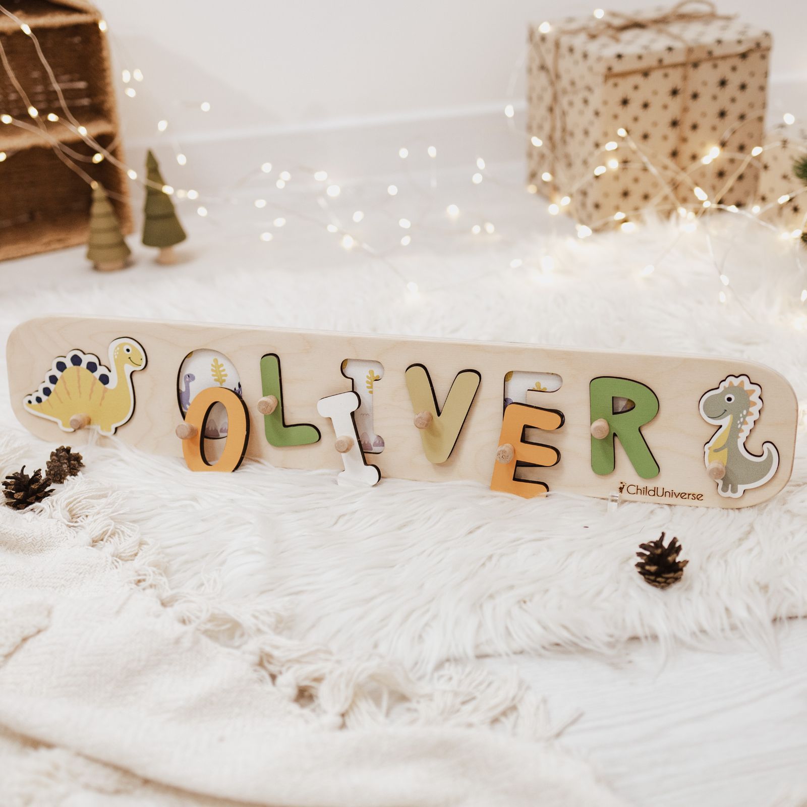 Neutral-toned dinosaur-shaped wooden name puzzle for children in beige, green, and yellow.