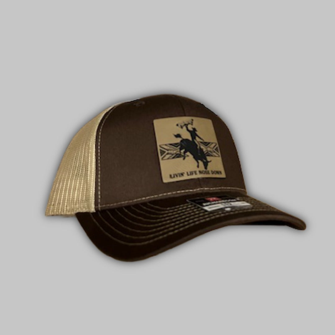 Unisex Bull Rider trucker hat in brown, tan, red, and black with Richardson 112 branding.