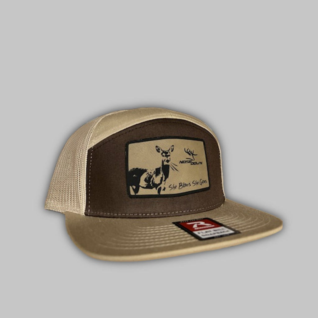 She Blows She Goes branded 7-panel camo flat-bill snapback hat.