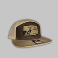 She Blows She Goes branded 7-panel camo flat-bill snapback hat.