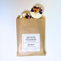 A 4-pack of natural shower steamers featuring dried orange, rose, and lavender botanicals in sustainable kraft packaging.