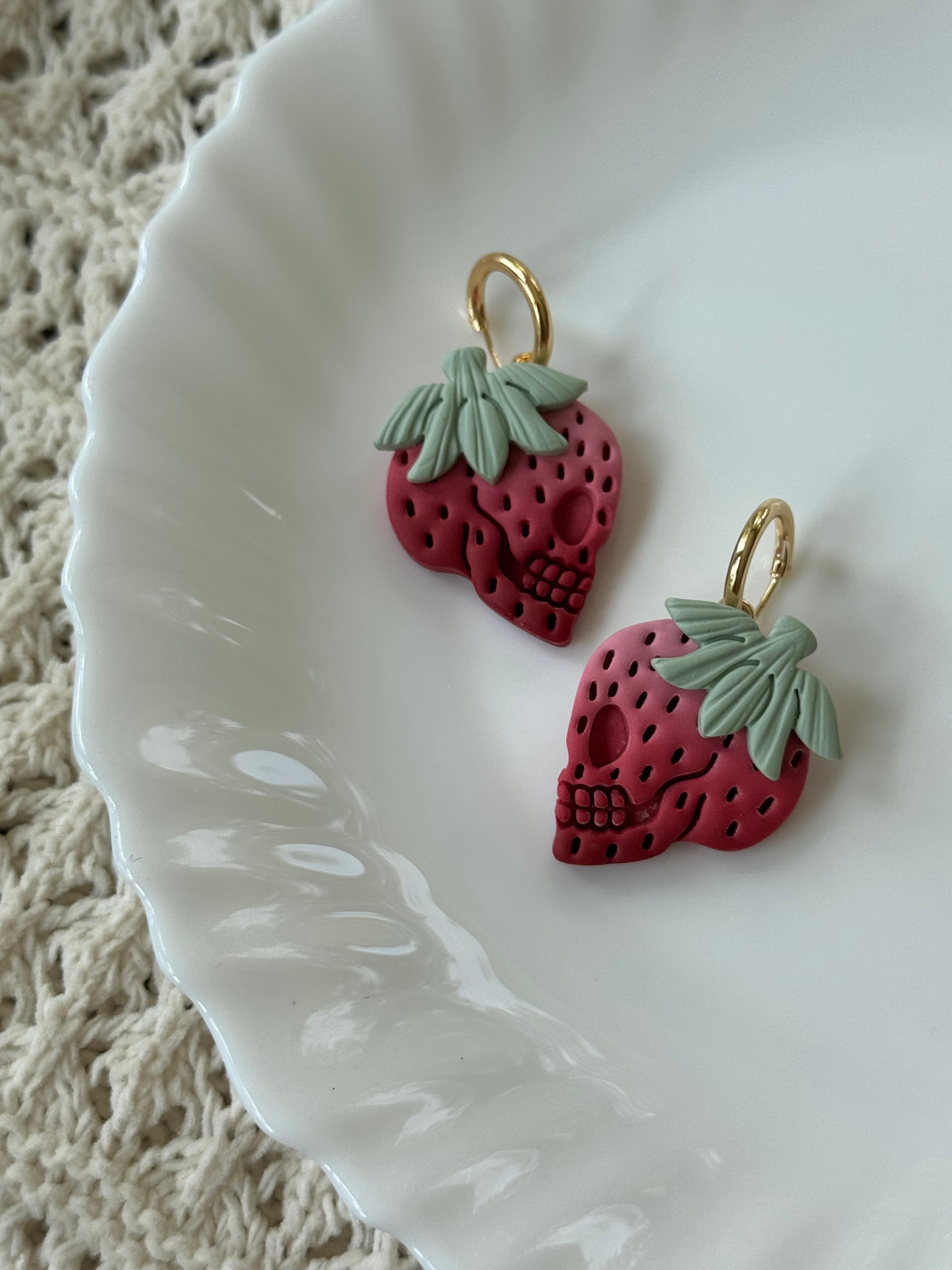 Skullberries handmade polymer clay earrings in red, green, and gold.