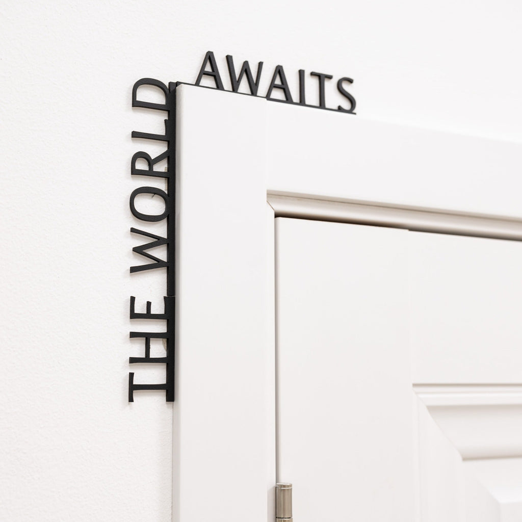 The World Awaits wooden inscription mounted above an entryway door