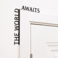 The World Awaits wooden inscription mounted above an entryway door