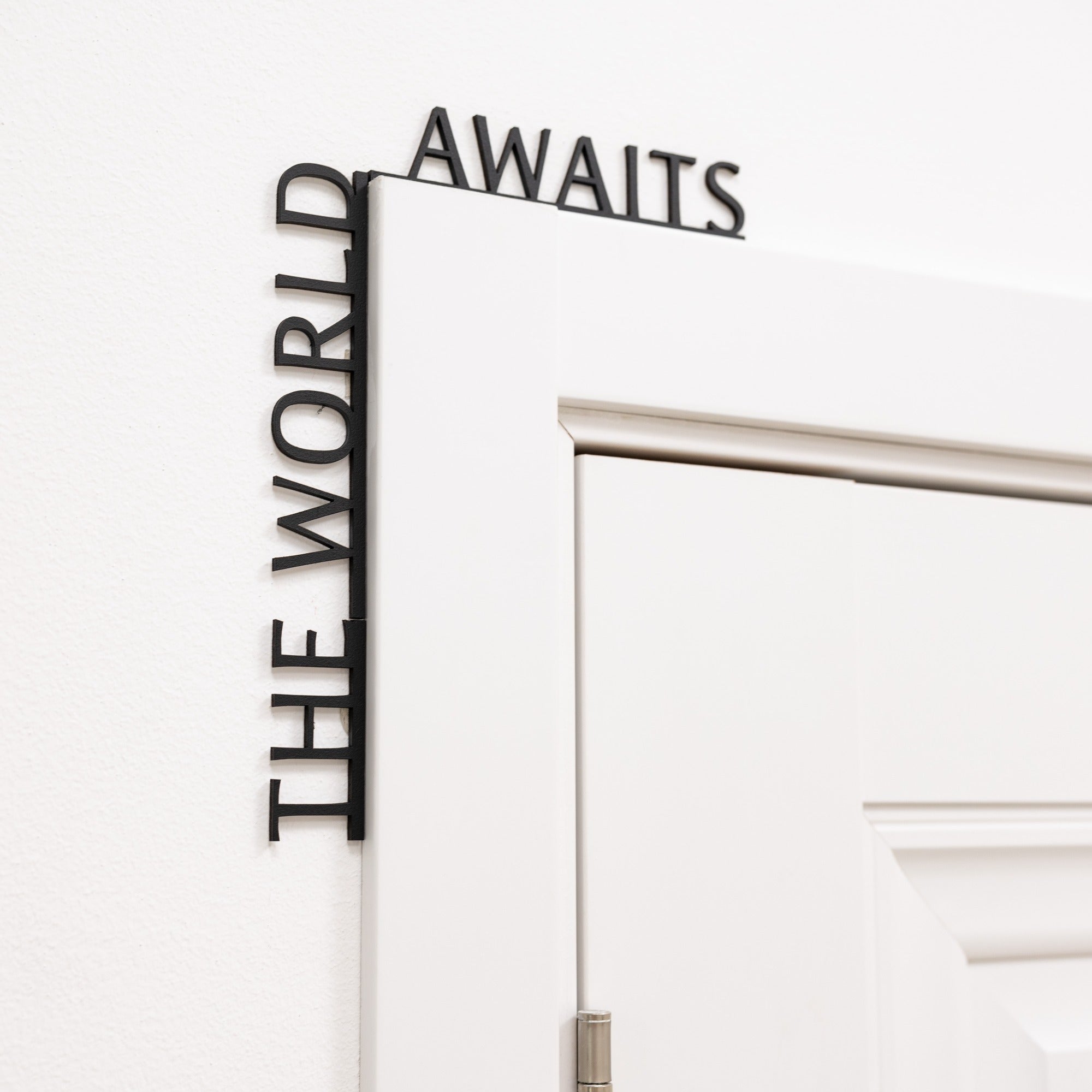 The World Awaits wooden inscription mounted above an entryway door