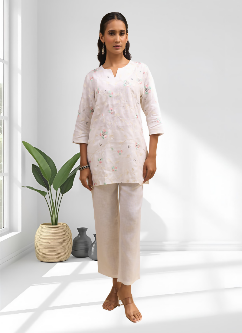 Off-white linen cord set featuring intricate embroidery and a flattering split V-neckline.