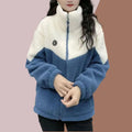 Woman wearing a plush color-block fleece jacket with front zipper and high collar