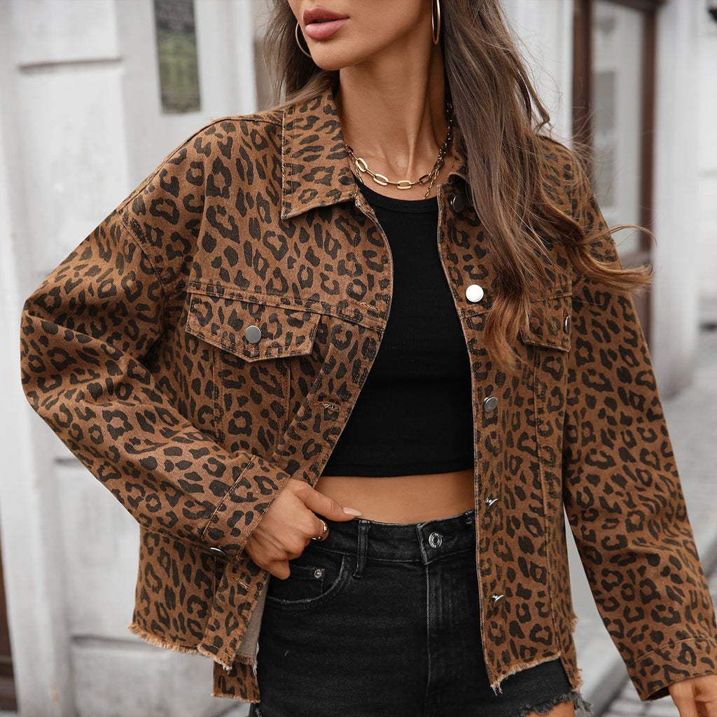Woman wearing a loose fit leopard print denim jacket with a black crop top and black shorts, styled for urban street fashion.