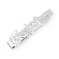 Silver tone tie bar with script lettering reading Best Man displayed on a pink paisley tie
