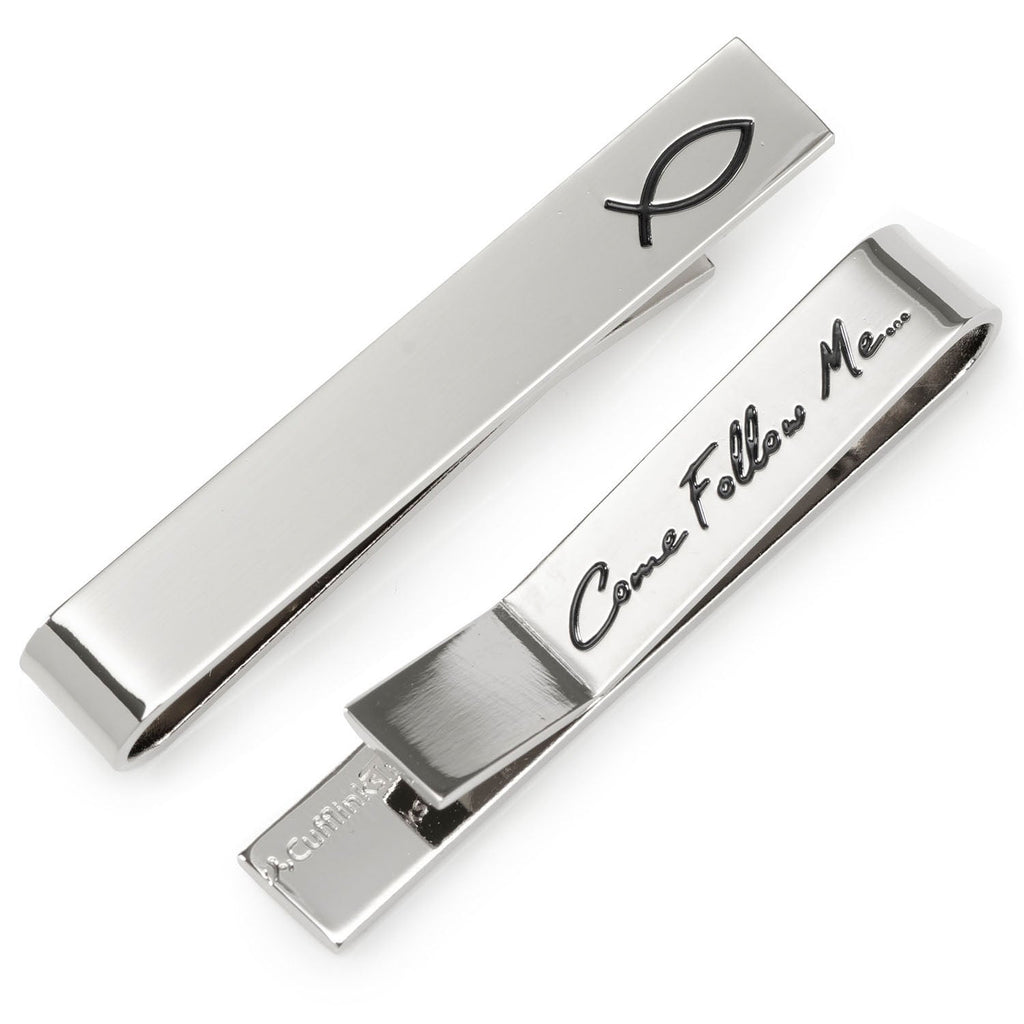 Silver tone tie bar featuring an ichthys fish symbol on the front and Come Follow Me engraved on the back, shown on a black tie.