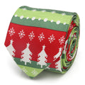 A close-up view of a rolled silk necktie featuring a repeating pattern of white Christmas trees and snowflakes on a red and green background.