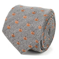 Close up of a black and white herringbone patterned necktie with small orange pumpkin motifs