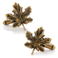 A pair of 3D bronze maple leaf shaped cufflinks on a white background, featuring bullet backings.