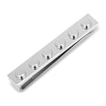 Silver tie bar with a building block design clipped onto a black necktie.