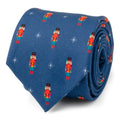 Navy blue men's necktie featuring a repeating holiday print of colorful nutcracker figures and white star icons.