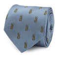 Close up of a light blue silk necktie with a repeated yellow and green pineapple pattern.