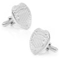 A pair of silver-plated police badge cufflinks featuring detailed engravings and bullet back closures