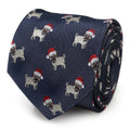 Close-up of a navy blue necktie featuring an all-over print of pugs wearing Santa hats, coiled on a white background.