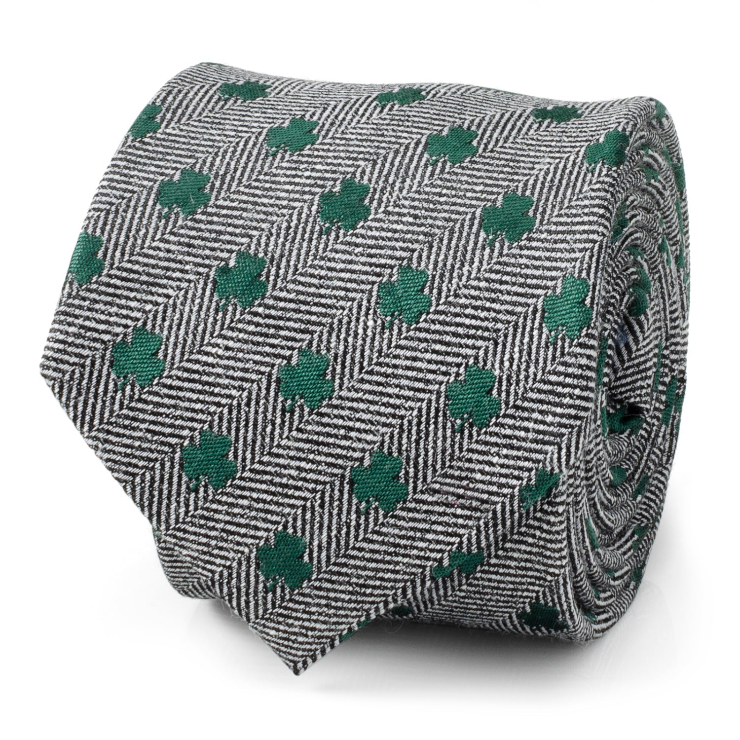 Close up and worn view of a gray herringbone necktie with small green shamrock patterns.