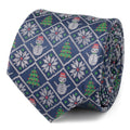 Close up of a blue silk men's necktie with a diamond pattern of snowmen, snowflakes, and christmas trees.