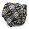 A close up view of a black and white plaid necktie with gold stag patterns, shown in a roll and on a mannequin.