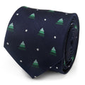 A close-up view of a midnight blue silk necktie with a pattern of miniature green Christmas trees and small white snow dots.