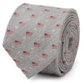 A light gray necktie featuring a herringbone pattern and small American flag prints, shown in a roll and on a mannequin.