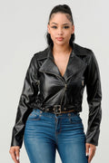 A woman wearing a fitted black PU leather moto jacket with a belt, paired with blue jeans.