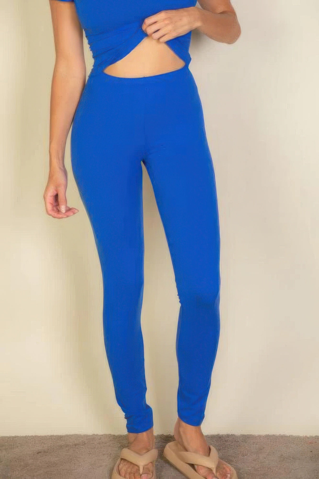 Person wearing bright blue leggings on a plain background