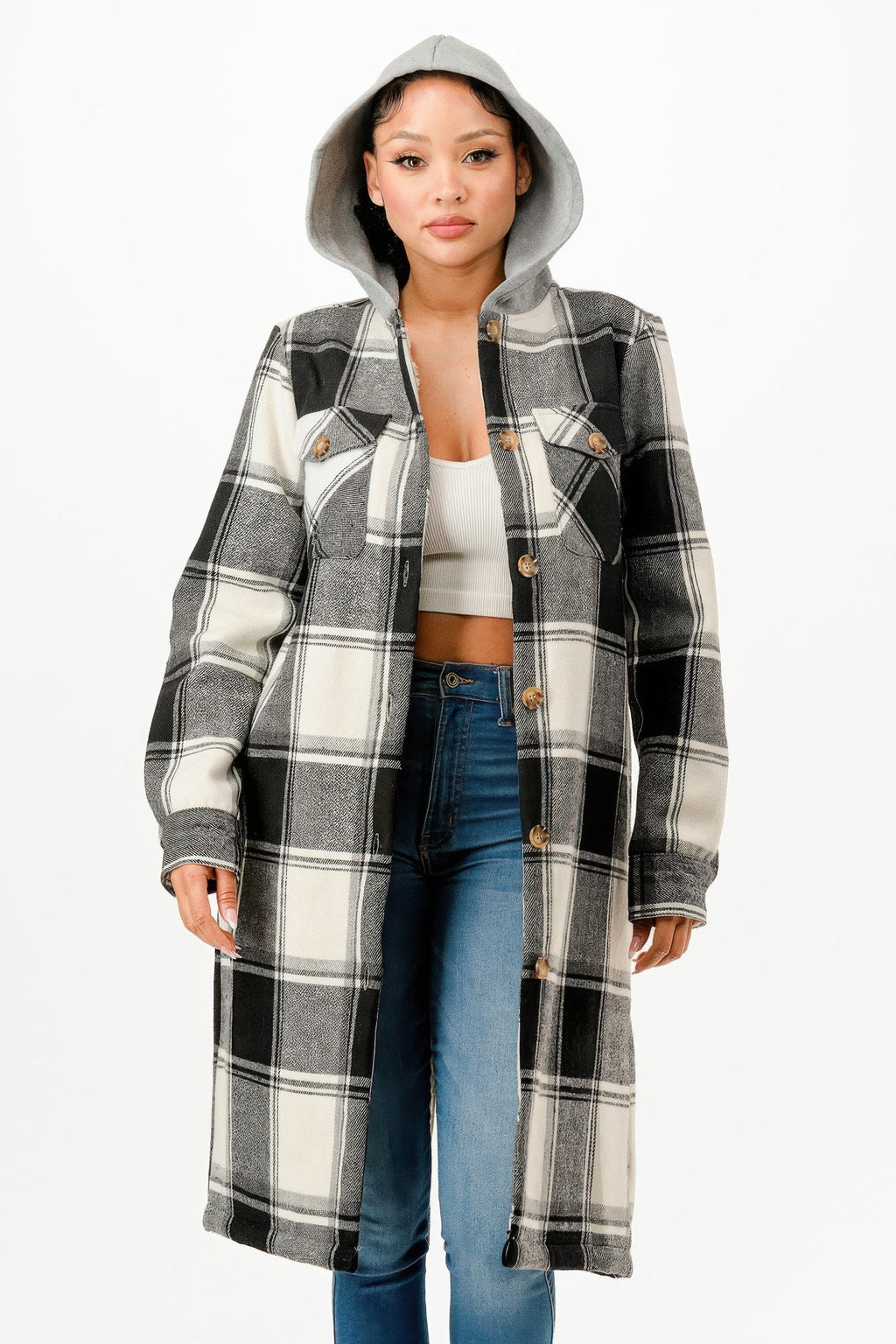 Model wearing a black and white hooded plaid long coat with a button-up front over a white top and blue jeans