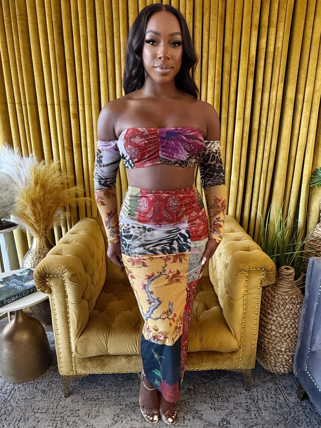 Model wearing a Wild Muse two-piece patchwork print set with a bandeau top and matching maxi skirt.