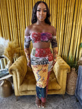 Model wearing a Wild Muse two-piece patchwork print set with a bandeau top and matching maxi skirt.