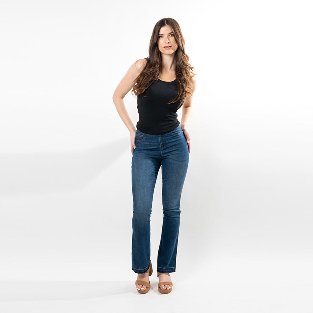 Model wearing dark wash bootcut jeans with an undone hem and adjustable waist