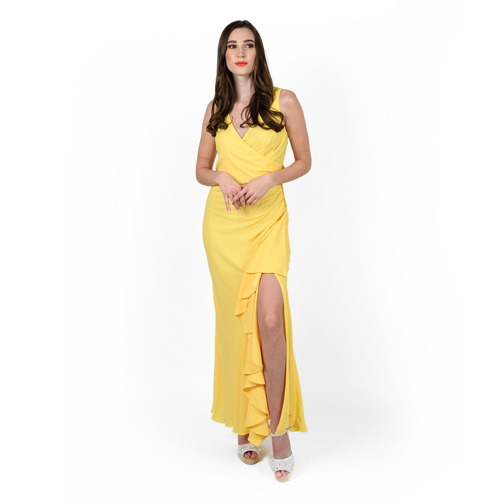 A woman wearing a yellow asymmetric wrap dress with a v-neck, draped detailing, and a flounced high-slit leg opening.