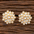 A pair of traditional Kundan pearl drop earrings with a golden white finish.