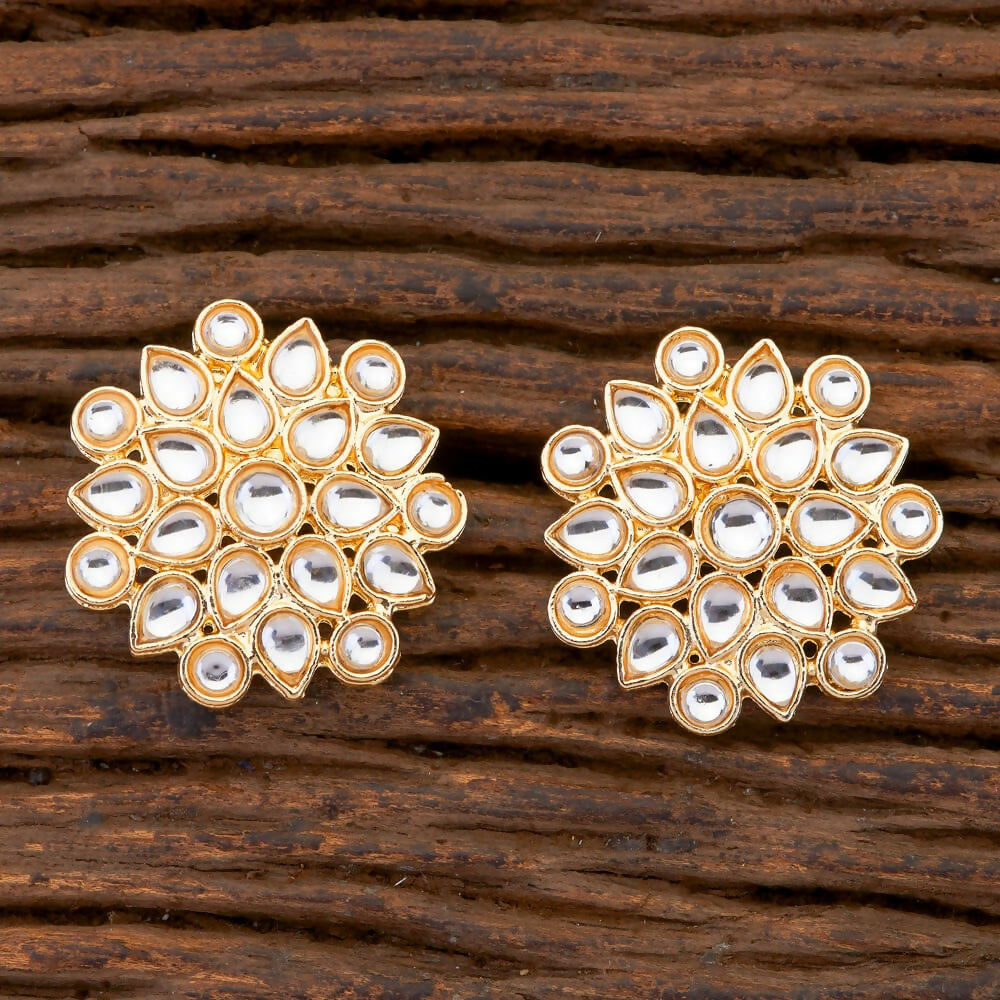 A pair of traditional Kundan pearl drop earrings with a golden white finish.