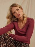 Nimia feather rib puff shoulder top in burgundy featuring a scoop neckline and long sleeves.