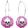 A pair of dangle hoop earrings featuring a skull centered within a pink flower design