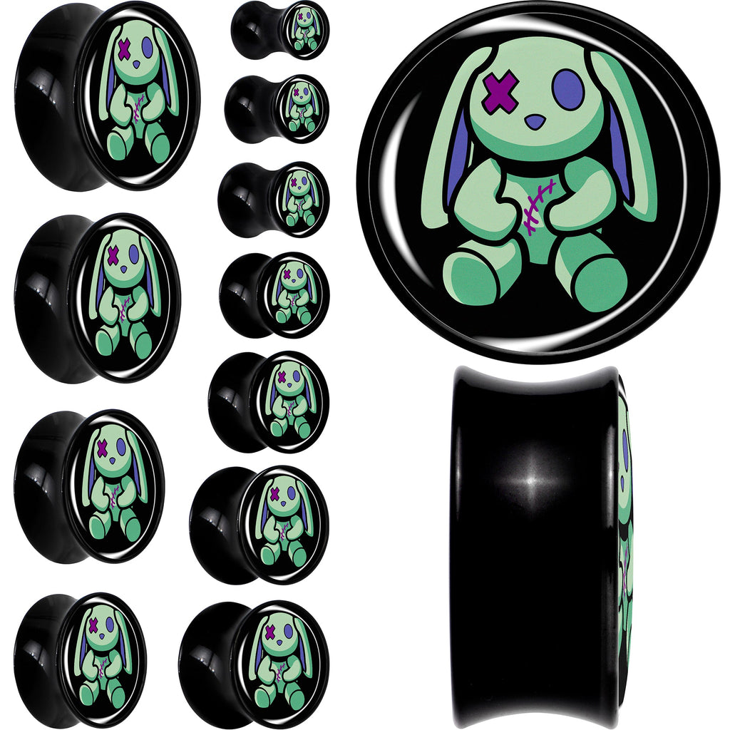 A set of black acrylic saddle plugs featuring a green zombie bunny character design