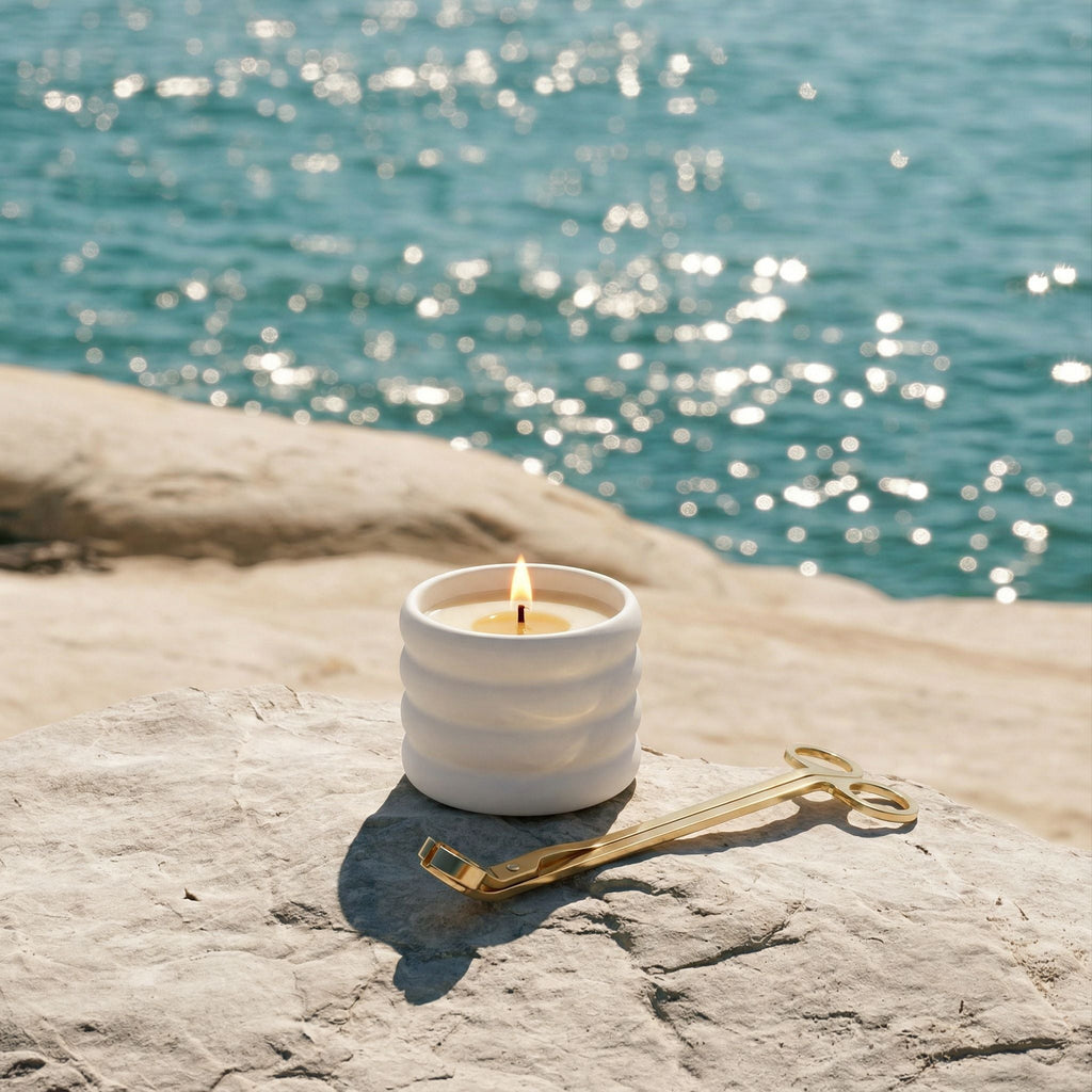 Ceramic ribbed candle in lilac next to a gold candle wick trimmer