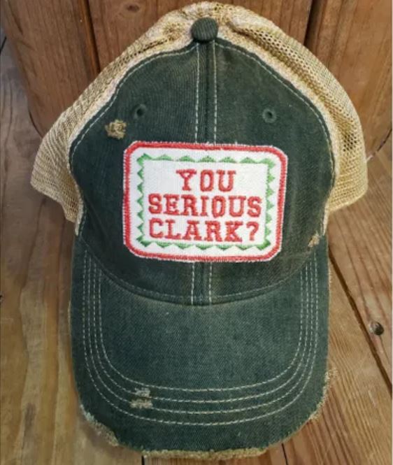 Distressed green trucker hat with tan mesh back and a rectangular patch reading You Serious Clark?