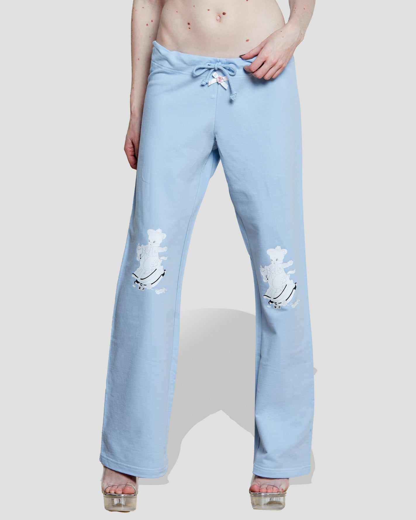 Pastel blue wide-leg sweatpants featuring dancing teddy cowboy embroidery and a satin bow drawstring detail.
