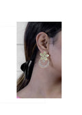 A pair of elegant Golden White AD stone brass earrings for women.