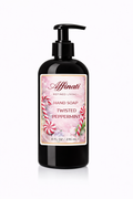 A black pump bottle of Twisted Peppermint hand soap with a festive label featuring candy canes and snowflakes.