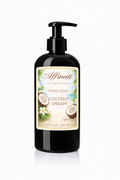 A black pump bottle of Coconut Dream Hand Soap with a tropical themed label featuring coconuts and flowers on a white background.