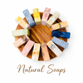 A collection of minimalist natural soap bars in vibrant orange, pastel pink, and creamy off-white tones.