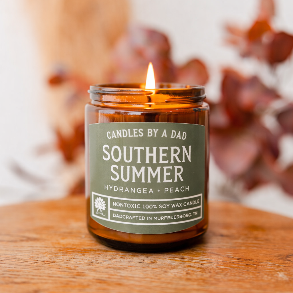 A 7oz Southern Summer scented soy wax candle in an amber glass jar on a wooden surface.