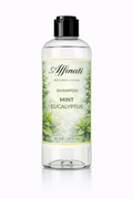 A clear 16oz bottle of Mint Eucalyptus Shampoo with a botanical label featuring mint leaves and white flowers against a white background.