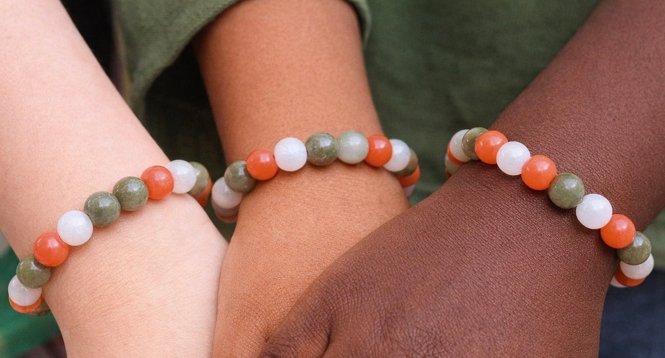 Youth Harmony Beaded Bracelet with green, white, and orange stones on a child's wrist