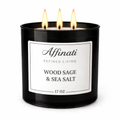 A 17 oz black 3-wick candle with a white label labeled Wood Sage & Sea Salt by Affinati, glowing with three lit flames.
